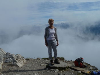 Woman standing on mountain against sky