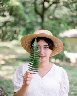 Portrait of woman wearing hat standing outdoors