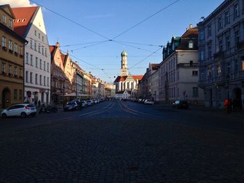 View of city street and buildings against sky