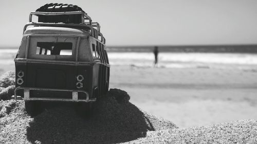 Close-up of sunglasses on beach against clear sky