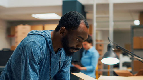 Side view of young man working at table