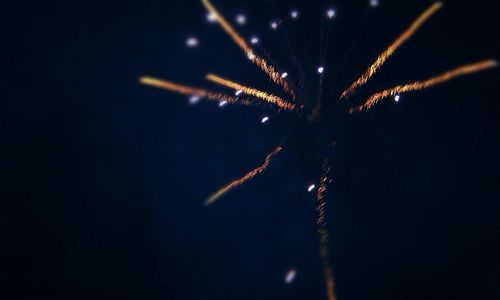 Low angle view of firework display at night