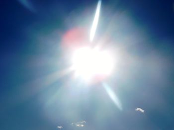 Low angle view of bright sun in sky