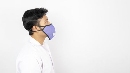 Side view of young man against white background