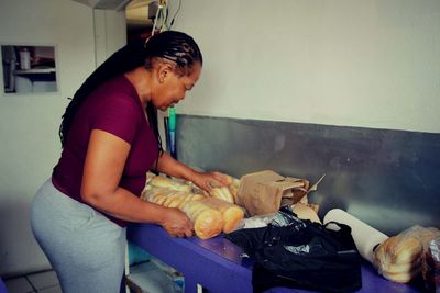 Side view of woman preparing food at home