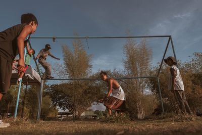 Men playing with arms raised against sky