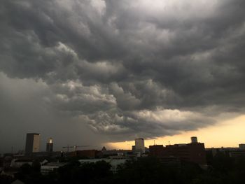 View of cityscape against cloudy sky