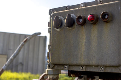 Close-up of machine part against sky