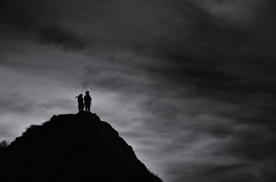 Low angle view of silhouette man standing against sky during sunset