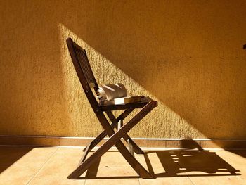 Minimalistic shot of wooden chair with a book on it sitting in the bright sunlight