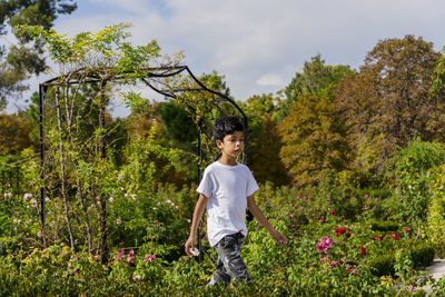 Young boy walking calmly in the park.