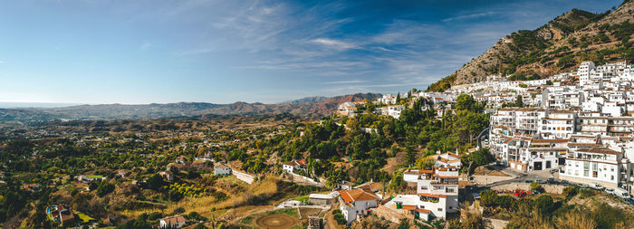 High angle view of houses and trees in town against sky