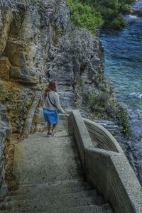 Rear view of woman standing on rock