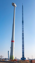 Low angle view of communications tower against blue sky