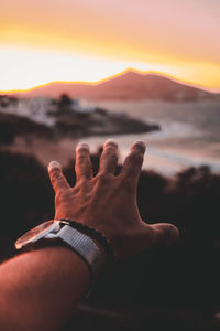 Close-up of hand during sunset