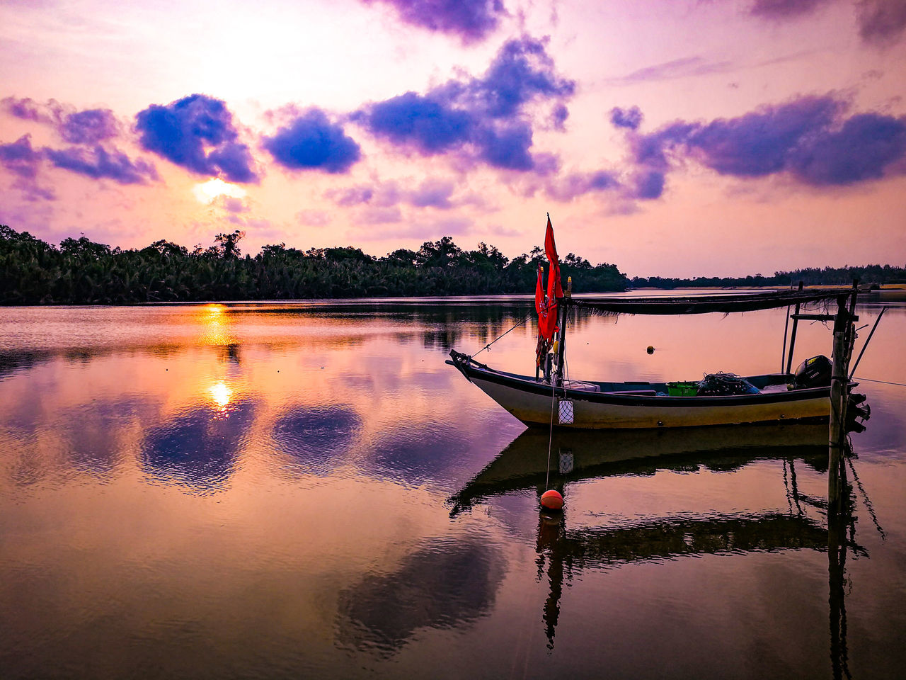 FISHING BOAT ON LAKE AGAINST SKY DURING SUNSET