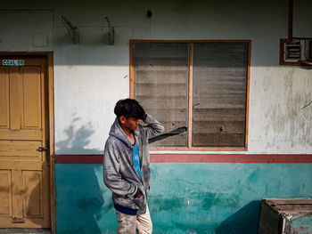 Side view of woman standing against building