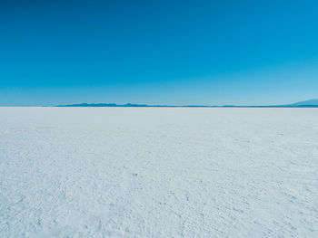 Scenic view of desert against clear blue sky