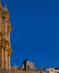 Low angle view of historic building against blue sky