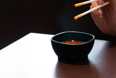 Close-up of person holding tea cup on table