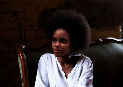 Black woman resting on green velvet sofa