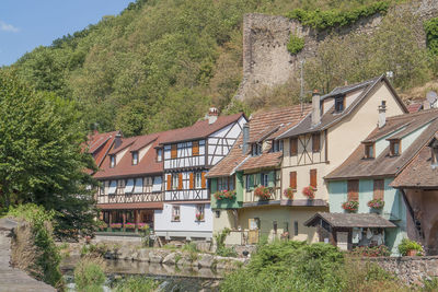 Houses by trees and mountains against sky