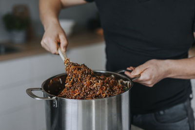 Man's hands mixing food in saucepan