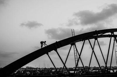 Low angle view of bridge against cloudy sky