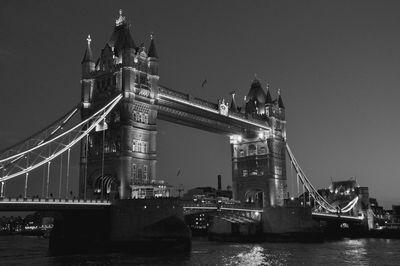 Low angle view of illuminated tower bridge over thames river against clear sky