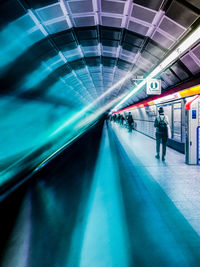 People walking in illuminated tunnel