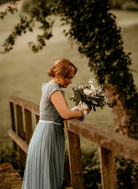Bridesmaid, alone, lonely, holding bouquet.