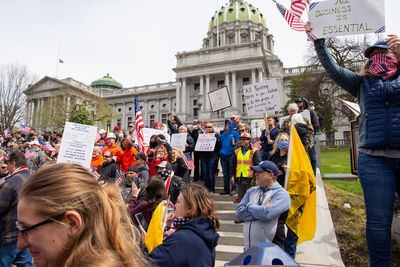 People on street against buildings in city