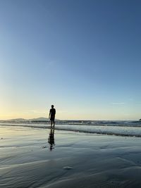 Man standing on snow covered land against sky