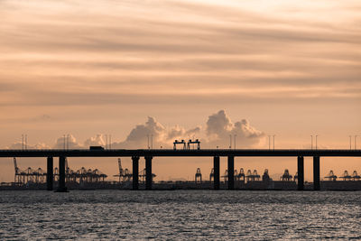 Pier over sea against sky during sunset