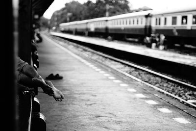 Low section of man lying on seat at railroad station platform