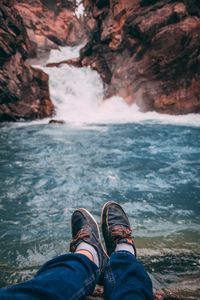 Low section of man on rock in sea