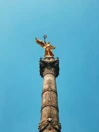 Low angle view of angel statue against clear blue sky