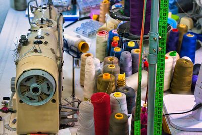 Sewing machine, thread, needles, pins, tailor's yardstick in a small studio.