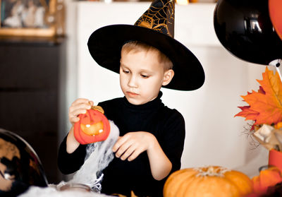 Boy holding pumpkin at home