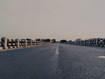 Road by buildings against sky in city