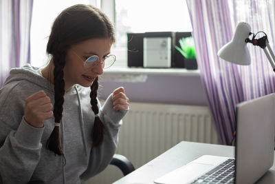 A teenager is pleased after checking her school test scores.