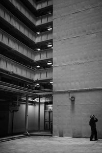 Rear view of man standing by illuminated building