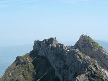 Rock formations in sea against clear sky