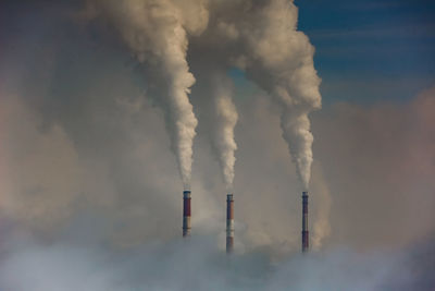 Smoke emitting from chimney against sky