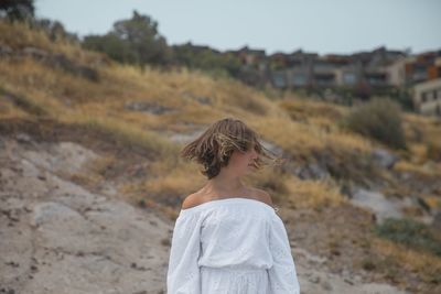 Teenage girl tossing hair while standing on land