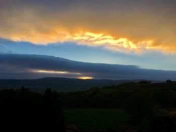 Scenic view of silhouette mountains against sky at sunset