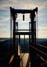Railing by sea against sky during sunset