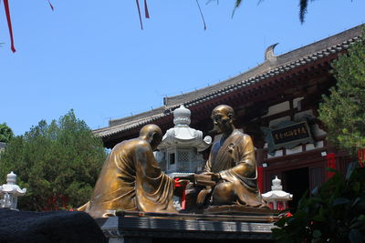 Statues on building against clear sky