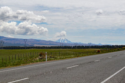 Road leading towards mountain against sky