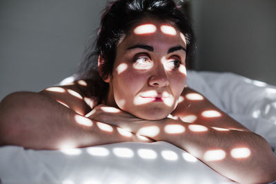 Smiling woman lying on bed at home